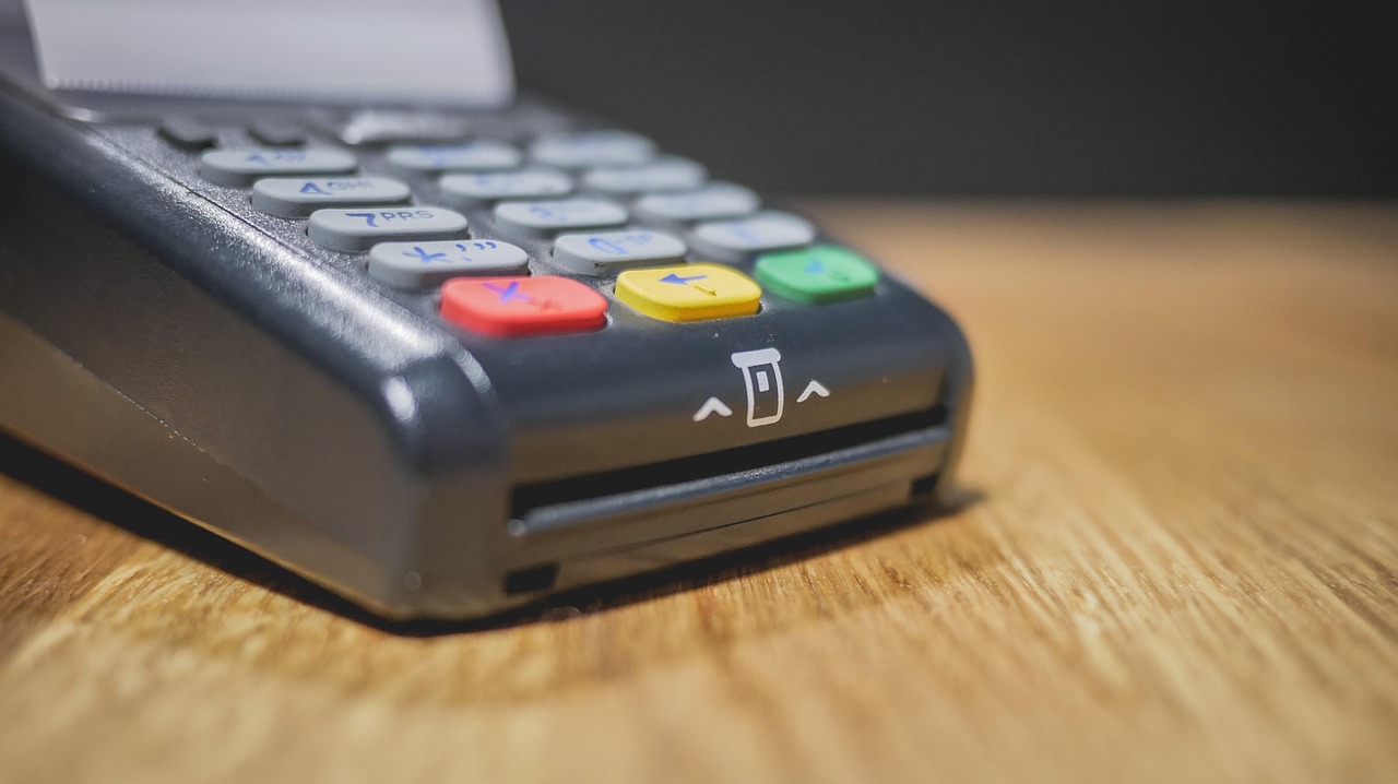 Commerciante che utilizza un POS per elaborare un pagamento, evidenziando le nuove regole.