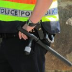 Agente di polizia penitenziaria in uniforme, riflettendo sul suo lavoro e stipendio.