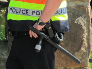 Agente di polizia penitenziaria in uniforme, riflettendo sul suo lavoro e stipendio.
