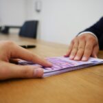 Donna che consulta documenti e un computer, riflettendo su un rimborso INPS.