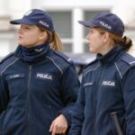 Vigile urbano in uniforme mentre controlla il traffico in una strada cittadina.